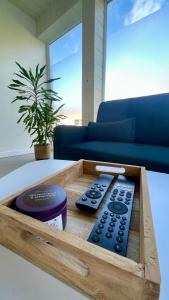 a wooden tray with two remote controls on a table at Gite OWEN in Bourbourg