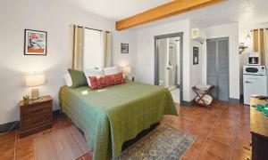 a bedroom with a bed with a green bedspread at Dam Site Lodging in Truth or Consequences