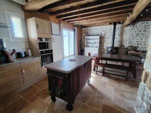 a kitchen with a island in the middle of a room at Les pierres qui parlent in Précilhon