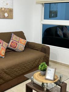 a brown couch in a living room with a table at Suite vista al Mar Salinas in Salinas