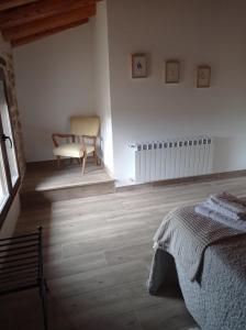 a bedroom with a bed and a chair in a room at Casa Paulina in Beceite +25 photos