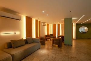 a living room with a couch and chairs at Regency Copacabana Hotel in Rio de Janeiro