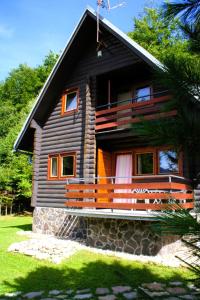 a wooden house with a bench in front of it at Chata Sova Tále in Bystrá