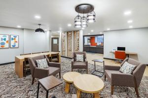 a lobby with chairs and tables and a waiting room at Candlewood Suites - Topeka West by IHG in Topeka