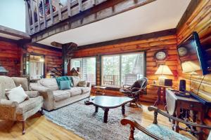a living room with wood paneling and a living room with a table at Adirondacks in Style! Lake House w/ Deck, Fire Pit in Hadley