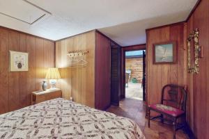 a bedroom with a bed and a chair in it at Adirondacks in Style! Lake House w/ Deck, Fire Pit in Hadley