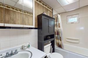 a bathroom with a sink and a black cabinet at Adirondacks in Style! Lake House w/ Deck, Fire Pit in Hadley +19 photos