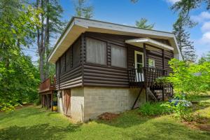 a small house in the middle of a yard at Adirondacks in Style! Lake House w/ Deck, Fire Pit in Hadley