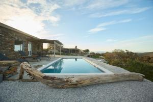 a swimming pool with a log in front of a house at Petra Vista Retreats in Otziás