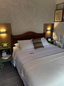 a bedroom with a large white bed with two lamps at Skema Collections Quito in Quito
