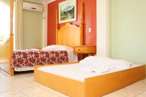 a hotel room with two beds and a mirror at Caverá Country Park in Araranguá