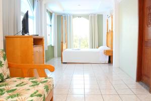 a living room with a tv and a couch and a bedroom at Caverá Country Park in Araranguá