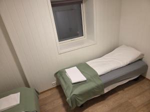 a small bed in a room with a window at The Old Printing House H0101 - 4 bedroom apartment in Tromsø