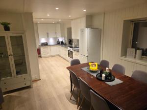 a kitchen with a table and chairs and a refrigerator at The Old Printing House H0101 - 4 bedroom apartment in Tromsø