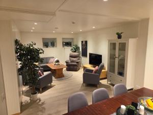 a living room with a couch and chairs and a table at The Old Printing House H0101 - 4 bedroom apartment in Tromsø
