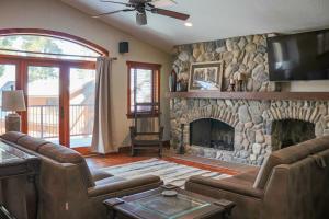 a living room with a stone fireplace and a tv at Good Ol Days Resort in Nisswa