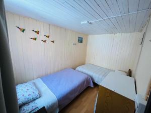 a small room with two beds and birds on the wall at Cabaña Terraza Choshuenco in Panguipulli