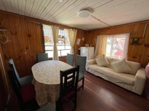a living room with a table and a couch at Cabaña Terraza Choshuenco in Panguipulli +2 photos