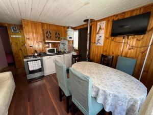 a kitchen with a table and chairs in a room at Cabaña Terraza Choshuenco in Panguipulli