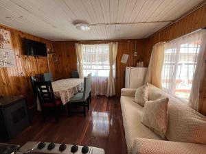 a living room with a couch and a table at Cabaña Terraza Choshuenco in Panguipulli