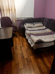 a bedroom with a couch and a wooden floor at City Relax in Bălţi