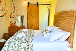 a bedroom with a bed with white sheets and pillows at Cottage Vanda in Le Moule