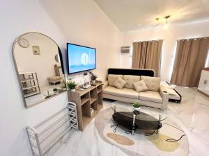 a living room with a couch and a large mirror at AJB Royal Ocean Crest Mactan Cebu in Cebu City