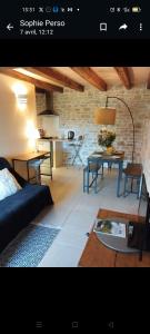 a living room with two tables and a couch at L'écurie du Mas in Lamothe-Cassel