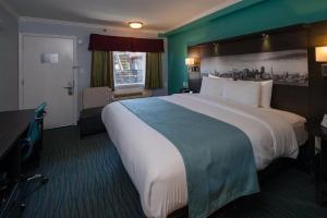a hotel room with a large bed and a window at Symphony Inn in San Francisco