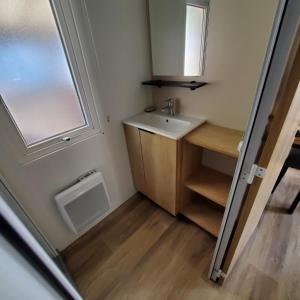 a small bathroom with a sink and a window at Vacances la Palmyre in Les Mathes +19 photos