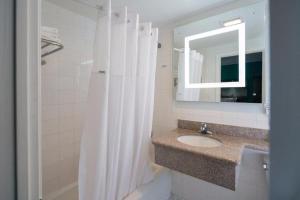 a white bathroom with a sink and a mirror at Symphony Inn in San Francisco +7 photos