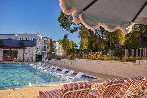 a swimming pool with lounge chairs next to a building at Landing Modern 2BD Gym Pool in Cornelius