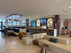 a hotel lobby with a couch and a bar at Cambria Hotel Euless - DFW Airport South in Euless