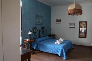 Schlafzimmer mit einem Bett mit blauer Tagesdecke in der Unterkunft Risveglio Ibleo in Ragusa