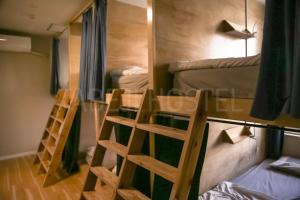 a room with two bunk beds and two ladders at Fukuoka Tabiji Hostel 福岡旅路ゲストハウス in Fukuoka