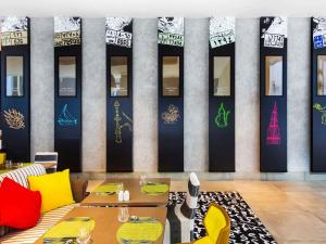 a dining room with a table and yellow chairs at ibis Styles Dubai Airport Hotel in Dubai