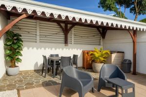 a patio with a table and chairs on it at Le cocon de Josie avec Jacuzzi & Piscine Privée, Le Lamentin, Martinique in Le Lamentin