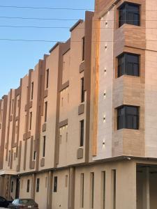a tall building with a car parked in front of it at مسكن ترف للشقق الفندقية in Al Majma'ah