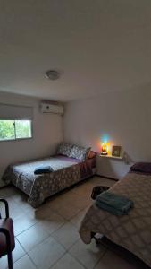 a bedroom with two beds and a table with a lamp at La Angelica in Juana Koslay 