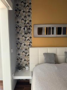 a bedroom with a bed and a wall at Apartman Golden in Senta