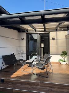two chairs and a table on a wooden deck at Apartman Golden in Senta