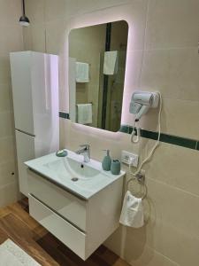 a bathroom with a white sink and a mirror at Apartman Golden in Senta +15 photos