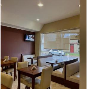 a dining room with a table and chairs and a car at Hotel Suite y SPA VerdeSolaro in Villa Elisa