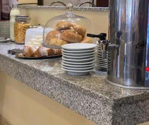 a counter with a pile of plates and pastries on it at Hotel Suite y SPA VerdeSolaro in Villa Elisa
