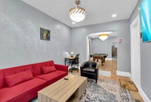 a living room with a red couch and a table at Cozy Corner Buffalo Getaway in Buffalo