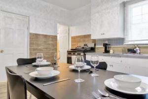 a kitchen with a table with plates and wine glasses at Cozy Corner Buffalo Getaway in Buffalo +7 photos