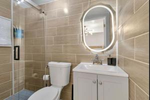a bathroom with a toilet and a sink and a mirror at Cozy Corner Buffalo Getaway in Buffalo