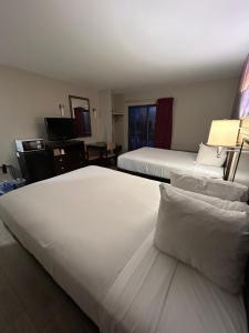 a hotel room with two beds with white sheets at Park Inn in Colchester