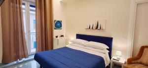 a bedroom with a blue bed and a window at due stanzulelle sul mare B&B in Salerno