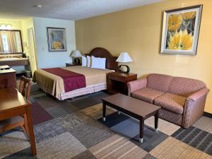 a hotel room with a bed and a couch at Thunderbird Motel in Elko +29 photos